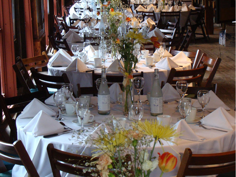 Table dressée pour un mariage, nappe blanche, bouquets et verres à vin